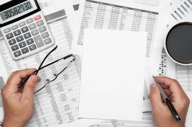 Finansal beyannamelerle çalışan iş adamlarının üst görüşü. Defteri, kalemi ve bir sürü şeyi olan modern siyah ofis masası. Düz masa düzeni.