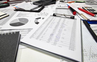 Ofis çalışanının masasının üst görünümü - mali raporlar, analiz ve muhasebe, tablolar ve grafikler, muhasebe için çeşitli ofis öğeleri ile çalışma