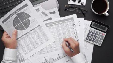 Finansal beyannamelerle çalışan iş adamlarının üst görüşü. Defteri, kalemi ve bir sürü şeyi olan modern siyah ofis masası. Düz masa düzeni.