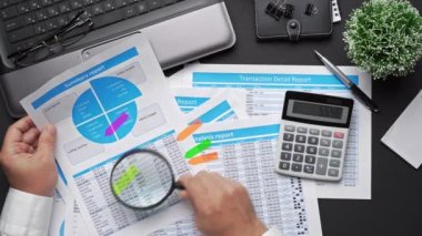 Finansal beyannamelerle çalışan iş adamlarının üst görüşü. Defteri, kalemi ve bir sürü şeyi olan modern siyah ofis masası. Düz masa düzeni.