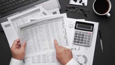 Finansal beyannamelerle çalışan iş adamlarının üst görüşü. Defteri, kalemi ve bir sürü şeyi olan modern siyah ofis masası. Düz masa düzeni.