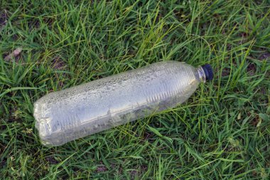 Çimlerin üzerinde çöp olarak plastik şişe kullanıldı, kirlilik kavramı