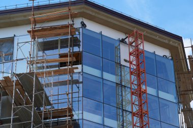 Modern bina yapım aşamasında, alçılı duvarlar ve iskeleler, inşaat vinci