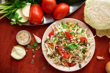 Sağlıklı yiyecekler - ahşap arka planda taze kesilmiş sebzeler, domatesler ve yeşiller