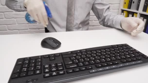 책상을 청소하거나 소독하는 사업가가 직장을 청소하고 컴퓨터 키보드 스프레이 살균기 — 비디오
