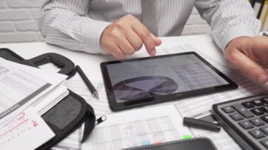 İş analizi ve muhasebe konsepti. Belge, hesap çizelgesi, hesap makinesi ve tablet bilgisayar kullanarak çalışan bir işadamı. Ofis masası kapanıyor..