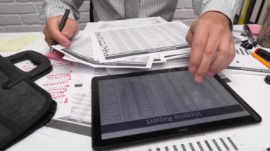 İş analizi ve muhasebe konsepti. Belge, hesap çizelgesi, hesap makinesi ve tablet bilgisayar kullanarak çalışan bir işadamı. Ofis masası kapanıyor.. 