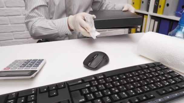 オフィスデスクの清掃または消毒の概念 ビジネスマンは職場 コンピュータキーボード ドキュメントフォルダをきれいにし スプレー銃の消毒剤 紙ナプキンを使用します — ストック動画