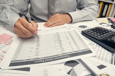 İş analizi ve muhasebe konsepti. Belge, hesap çizelgesi, hesap makinesi ve tablet bilgisayar kullanarak çalışan bir işadamı. Ofis masası kapanıyor..