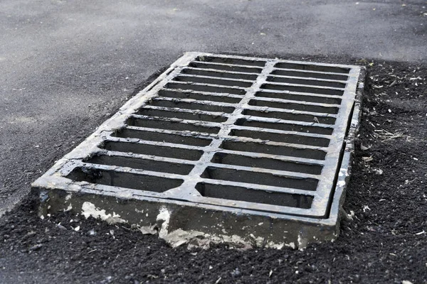 道路上或人行道上的新的雨水格栅 安装在混凝土中 暴雨期间排水的城市污水系统 — 图库照片
