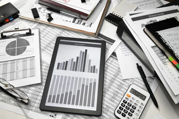 ビジネスオフィスデスククローズアップ 画面上のテーブルとグラフを持つタブレットコンピュータ 財務報告 分析と会計 帳簿書類のセット — ストック写真
