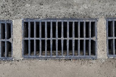 Yolda ya da kaldırımda yeni yağmur suyu ızgarası, beton döşeme. Şiddetli yağmurda suyu boşaltmak için şehir kanalizasyon sistemi