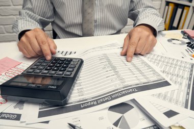 İş analizi ve muhasebe konsepti. Belge, hesap çizelgesi, hesap makinesi ve tablet bilgisayar kullanarak çalışan bir işadamı. Ofis masası kapanıyor..