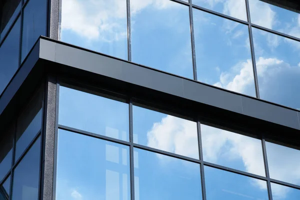 明るい晴れた日に近代的な建物のファサード ガラスに反映青い空と雲 新しい建物の美しい外観 — ストック写真