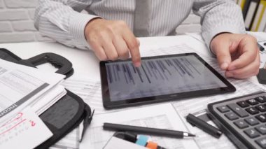 İş analizi ve muhasebe konsepti. Belge, hesap çizelgesi, hesap makinesi ve tablet bilgisayar kullanarak çalışan bir işadamı. Ofis masası kapanıyor..