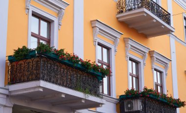 Sarı duvar ve balkon şehirde çiçeklerle süslenmiş.