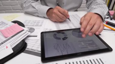 İş analizi ve muhasebe konsepti. Belge, hesap çizelgesi, hesap makinesi ve tablet bilgisayar kullanarak çalışan bir işadamı. Ofis masası kapanıyor..