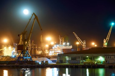 Geceleyin sanayi limanının görüntüsü - yükleme ve boşaltmayı bekleyen gemiler, deniz yoluyla kargo taşımacılığı