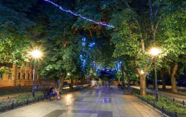 Ukrayna 'nın Odessa şehrindeki Primorsky Bulvarı' nın gece manzarası. Güzel şehir parkı ve sokak ışığı, yürüyen insanlar.