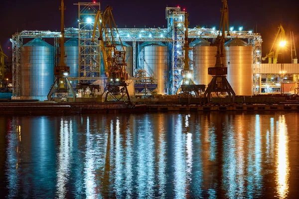 view of the industrial port at night - ships waiting for loading and unloading, cargo transportation by sea