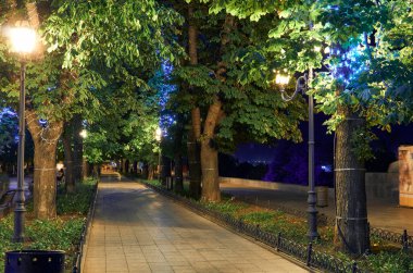 Ukrayna 'nın Odessa şehrindeki Primorsky Bulvarı' nın gece manzarası. Güzel şehir parkı ve sokak ışığı, yürüyen insanlar.