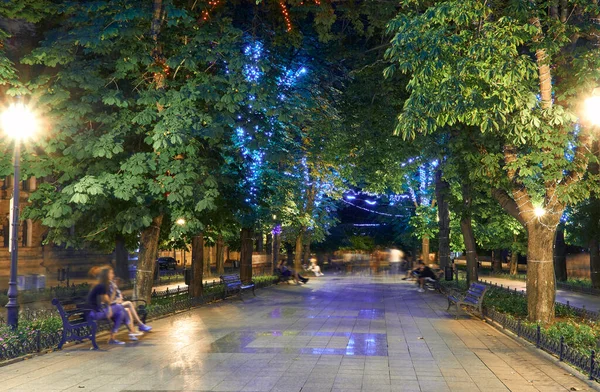 Ukrayna 'nın Odessa şehrindeki Primorsky Bulvarı' nın gece manzarası. Güzel şehir parkı ve sokak ışığı, yürüyen insanlar.