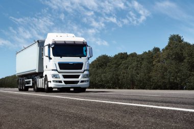 Yoldaki kamyon, ön görüş, beyaz bir konteynırdaki boş alan - kargo taşımacılığı, taşımacılık endüstrisi kavramı