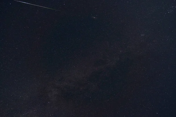 black night sky and stars as background, the milky way and falling Perseid meteors