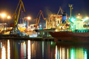 Geceleyin sanayi limanının görüntüsü - yükleme ve boşaltmayı bekleyen gemiler, deniz yoluyla kargo taşımacılığı