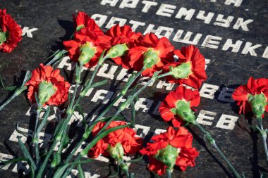 Tiraspol, Transnistria - 2 Eylül 2020: Bağımsızlığın 30. yıldönümü, şehit askerlerin anısına çiçekler, farklı isimlere sahip Rusça metin