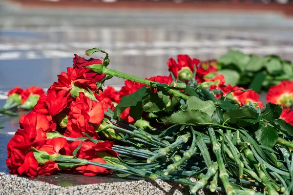 倒れた兵士への追悼の花 黒い大理石の赤いカーネーション ロシア語のテキスト 未知の兵士への記念碑 — ストック写真