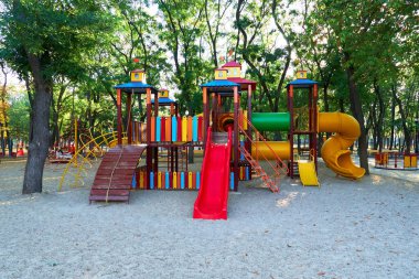Sabahın erken saatlerinde çocuk parkında, çeşitli salıncaklar ve atlıkarıncalarda
