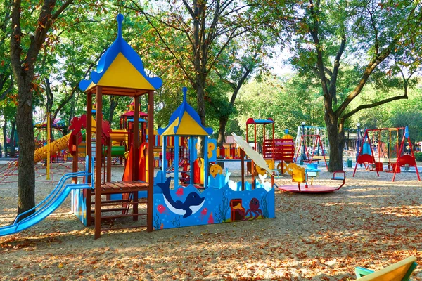 朝早く街の公園で子供の遊び場様々なスイングとカルーセル — ストック写真