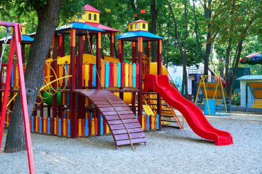 Sabahın erken saatlerinde çocuk parkında, çeşitli salıncaklar ve atlıkarıncalarda
