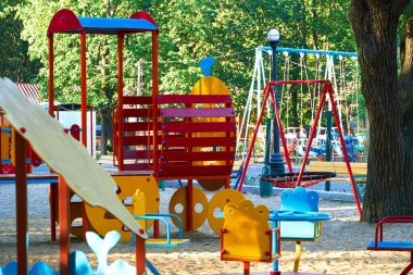 Sabahın erken saatlerinde çocuk parkında, çeşitli salıncaklar ve atlıkarıncalarda