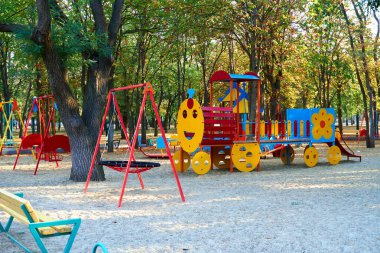 Sabahın erken saatlerinde çocuk parkında, çeşitli salıncaklar ve atlıkarıncalarda