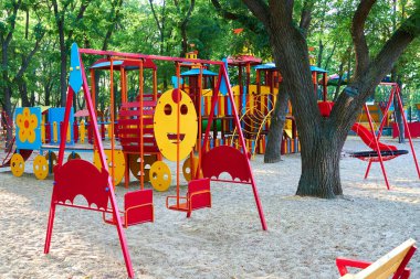 Sabahın erken saatlerinde çocuk parkında, çeşitli salıncaklar ve atlıkarıncalarda
