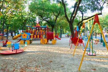 Sabahın erken saatlerinde çocuk parkında, çeşitli salıncaklar ve atlıkarıncalarda