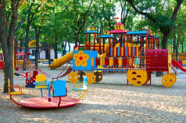 Sabahın erken saatlerinde çocuk parkında, çeşitli salıncaklar ve atlıkarıncalarda