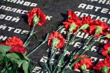 Tiraspol, Transnistria - 2 Eylül 2020: Bağımsızlığın 30. yıldönümü, şehit askerlerin anısına çiçekler, farklı isimlere sahip Rusça metin