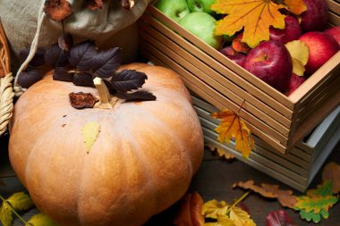 Arka plan olarak kırsal bir yaşam sürmeye devam ediyor. Yapraklar, sebzeler, meyveler, fındıklar ve diğer doğal besin maddeleri ahşap tahtalarda.