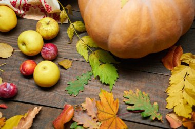 Arka plan olarak kırsal bir yaşam sürmeye devam ediyor. Yapraklar, sebzeler, meyveler, fındıklar ve diğer doğal besin maddeleri ahşap tahtalarda.