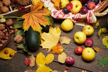 Arka plan olarak kırsal bir yaşam sürmeye devam ediyor. Yapraklar, sebzeler, meyveler, fındıklar ve diğer doğal besin maddeleri ahşap tahtalarda.