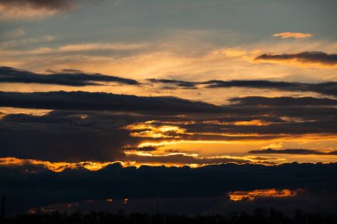 Güzel gün batımı gökyüzü, parlak güneş ve karanlık bulutların silueti bir arka plan olarak