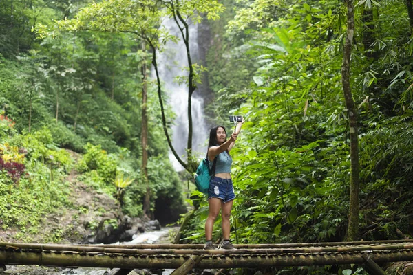 旅游妇女在曼德克莎丽丛林的红珊瑚瀑布附近的一座竹桥上自拍 在印尼巴厘岛 — 图库照片