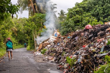 Tons of industrial rubbish burning along the road in the Banda Neira island, Indonesia clipart