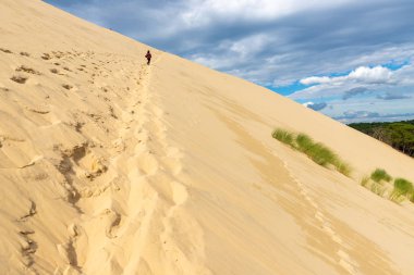 Kadın tırmanma pile dune Arcachon Bay, Aquitaine, Fransa