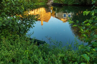 Marais Poitevin Kanalı, Coulon Köyü, Fransa 'da akşam karanlığında su yansıması.