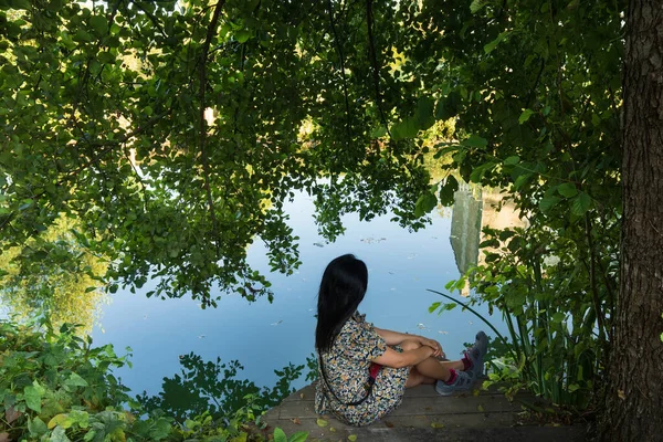 Mujer Sentada Orilla Del Río Contemplando Reflejo Del Agua Atardecer — Foto de Stock