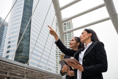 Amerikan işkadını patron iş proje planı onun AST subayı ile tartışın. Onay geliştirmek ilerleme yolu ile modern bina için dijital tablet ve nokta parmak.